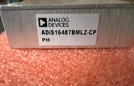 Electronic component with Analog Devices label on a pink textured background ADiS16487BMLZ-CP
