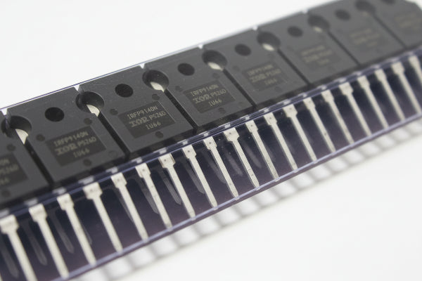 Close-up of electronic components with 'IRFP9140NPBF' branding on a metallic surface.