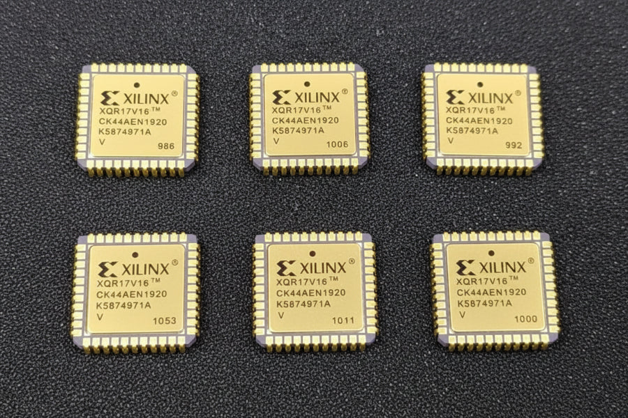 Five Xilinx chips on a dark surface